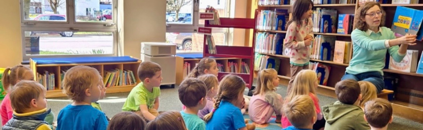 Librarian reads to a group of children during a class visit