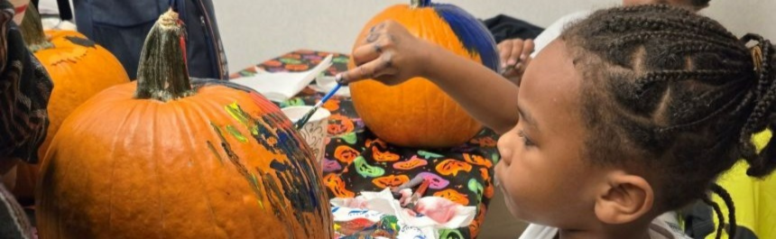 Child paints pumpkin