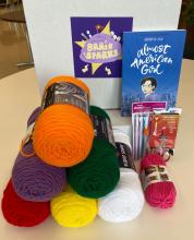 picture of stacks of yarn and the book Almost American Girl 