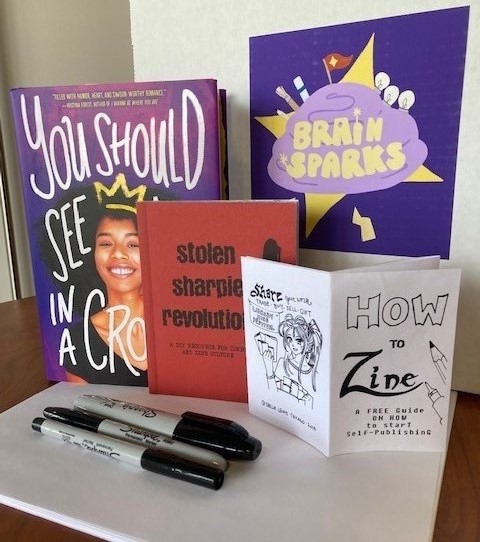 sharpie pens and two books, Stolen Sharpie Revolution and You Should See Me in a Crown