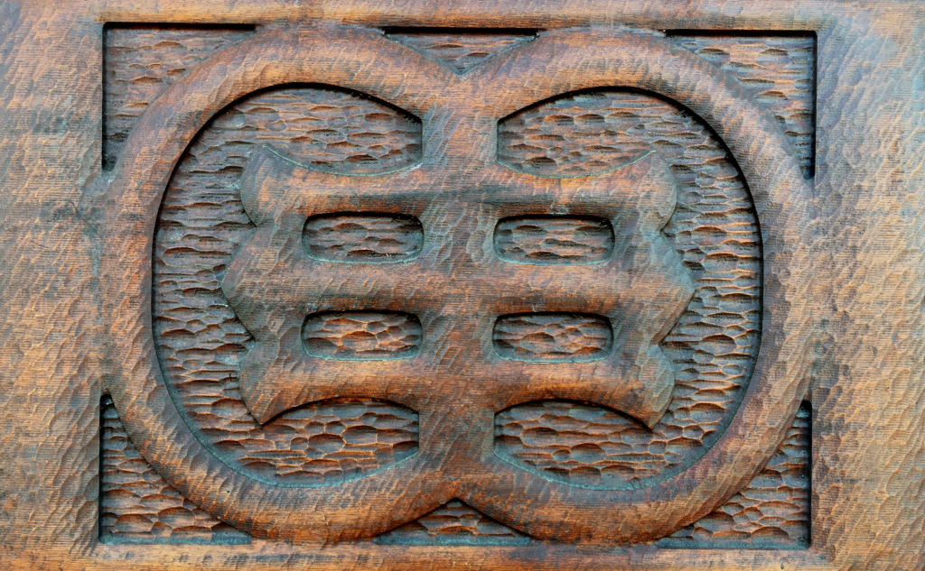 Photo of carved front doors, which means "Welcome" in Adinkra symbols